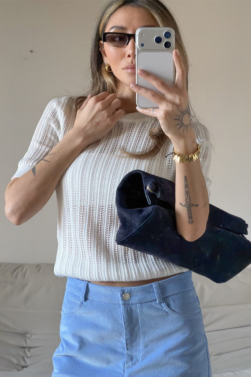 Pull femme à manches courtes porté avec une tenue décontractée