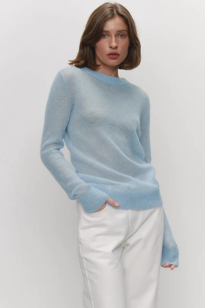 Pull femme à col rond porté dans une tenue décontractée.