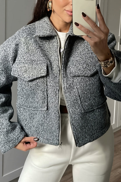 Détail de la texture bouclée et de la fermeture zippée de la veste