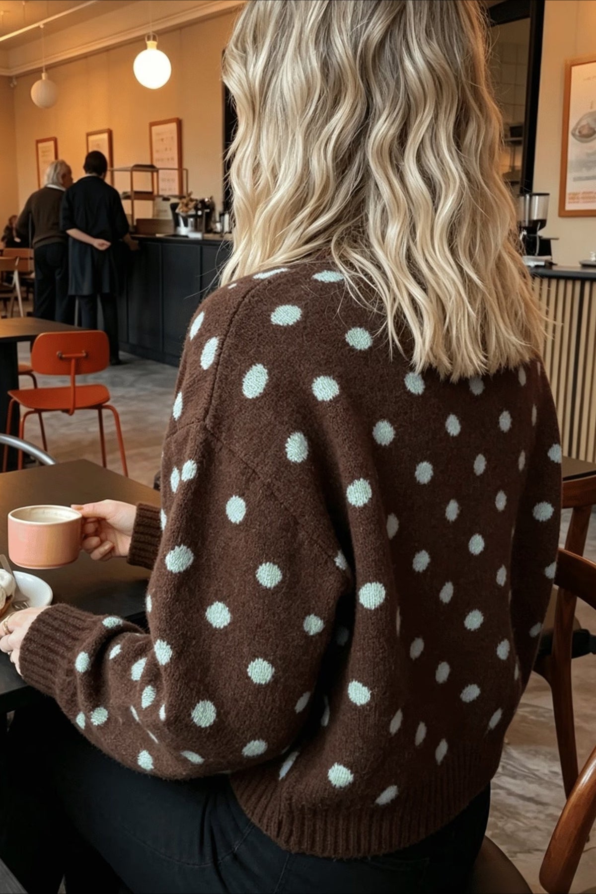 Vue rapprochée du pull marron à pois et de son col rond