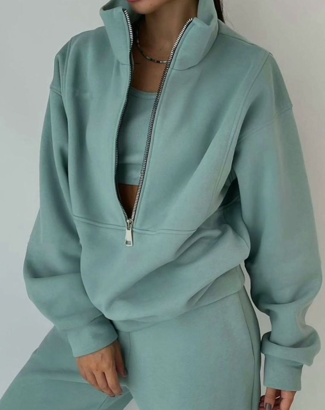 Sweat court femme à demi-zip porté avec un pantalon de jogging assorti